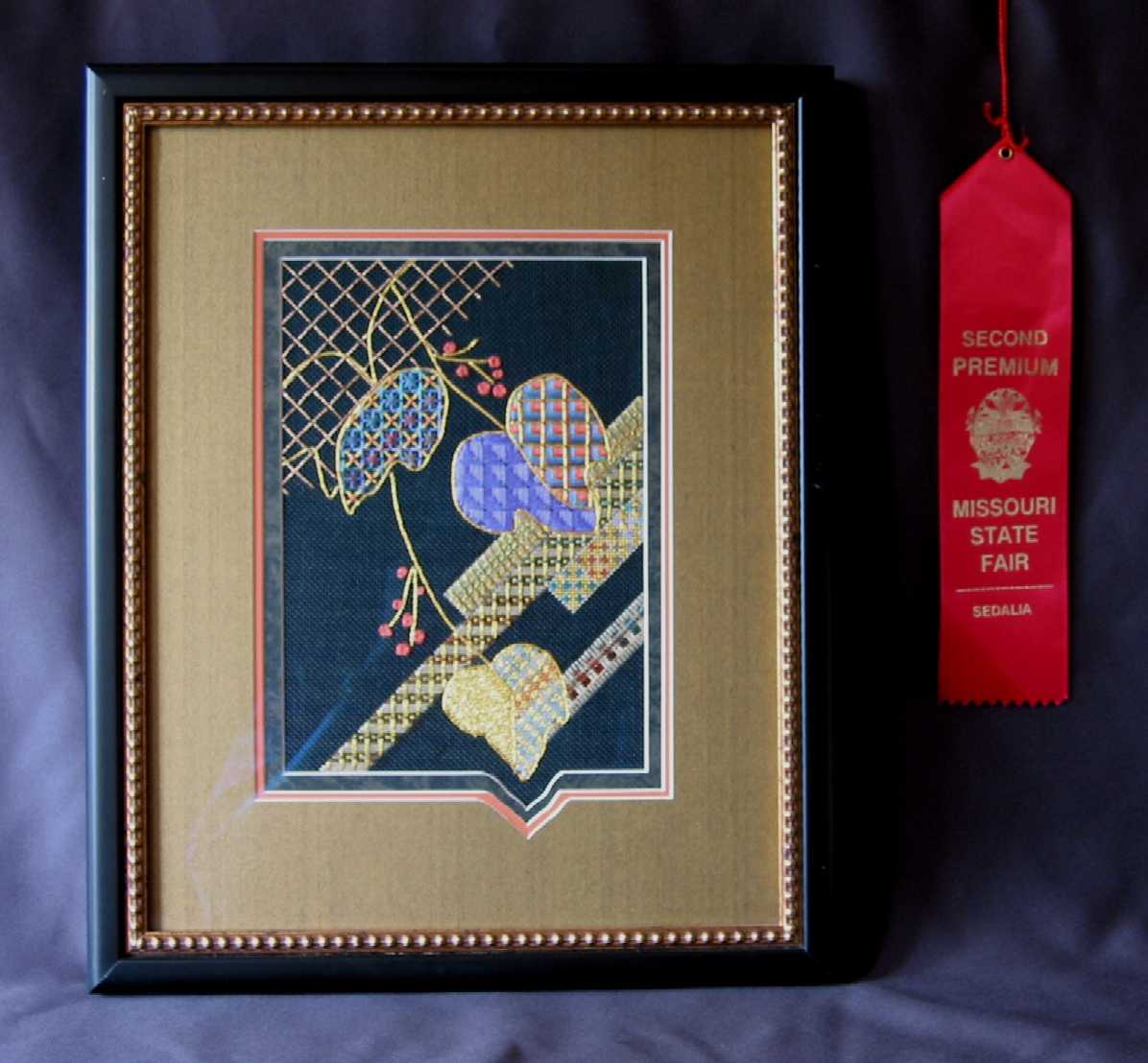 Framed award winning needlepoint with hand cut mat to match needlework design
